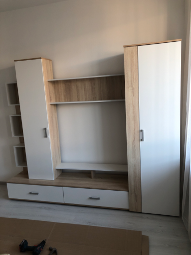 Собрана мебельная конструкция: установлены шкафы, полки, ящики. Все элементы надежно закреплены, дверцы и ручки установлены, обеспечена устойчивость и функциональность.