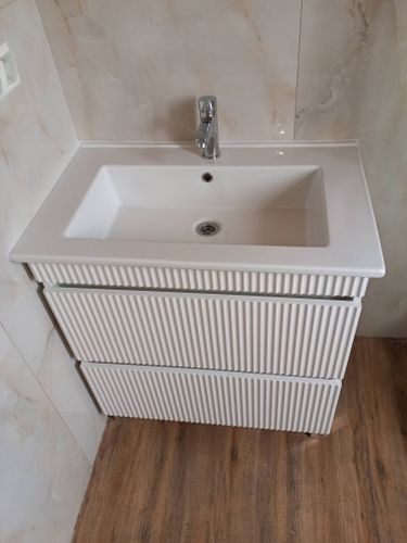 Установлена новая раковина с краном, подключены водопроводные трубы, выполнена герметизация швов, проверена работа слива, обеспечена надежная фиксация на тумбе, завершен монтаж.