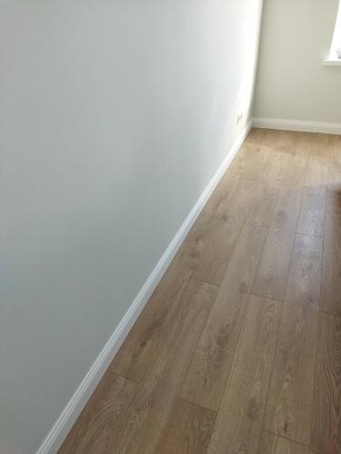 Установлен новый напольный плинтус, аккуратно прилегающий к стене и полу. Завершено оформление стыков, обеспечена надежная фиксация. Создана гармоничная граница между поверхностями.