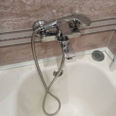 Изображен установленный новый смеситель с подключенными шлангами, надежно закреплен на раковине. Все соединения герметичны, обеспечивая бесперебойное водоснабжение.