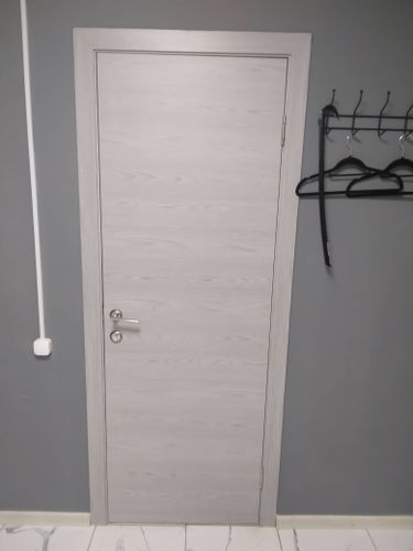 Установлена новая дверь: закреплены петли, врезан замок, отрегулирована створка, обеспечена плавная работа, добавлены наличники, завершена отделка.