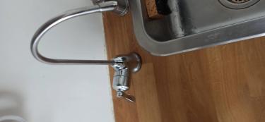 Под раковиной закреплена система очистки, подключены шланги, установлен отдельный кран для подачи чистой воды. Все соединения герметично зафиксированы, обеспечивая надежную работу.