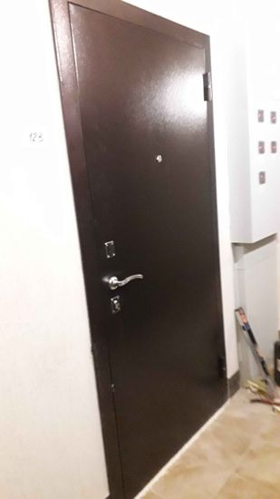 Дверь покрыта панелями из МДФ, что придаёт ей современный вид. Установлены новые ручки и замки, обеспечивающие безопасность и удобство использования. Работа выполнена аккуратно и качественно.