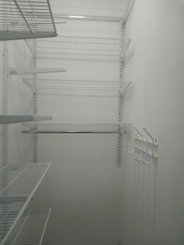 Установлены металлические полки на стене, закреплены кронштейны, добавлены крючки для организации пространства. Завершено аккуратно и надежно.