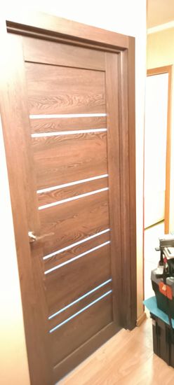 Установлена деревянная створка, закреплены петли, врезан замок, отрегулированы зазоры, смонтирован наличник, проверена плавность хода, завершена отделка, обеспечена надежная фиксация.