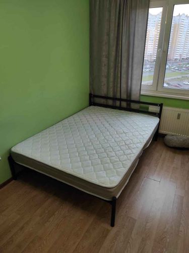 Собрана металлическая конструкция, установлены ножки, закреплено изголовье, уложен матрас. Кровать размещена в комнате у окна, завершена сборка и проверена устойчивость.