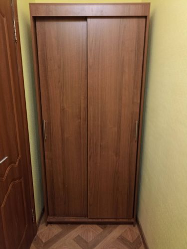 Собран корпус, установлены раздвижные двери, закреплены ручки, отрегулированы механизмы, проверена устойчивость, завершена установка в нишу, обеспечена плавность движения створок.