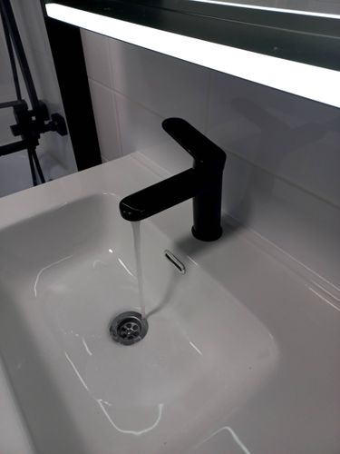 Завершена установка зеркала в ванной комнате. Зеркало надежно закреплено на стене над раковиной, обеспечивая удобство использования и эстетичный вид.