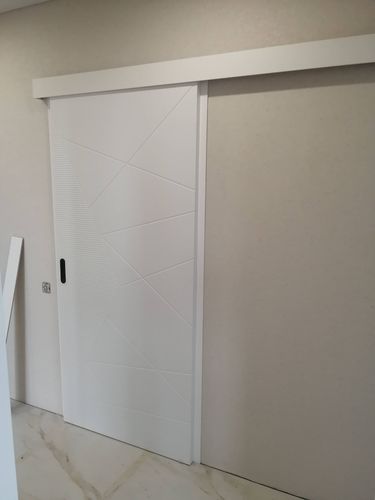 Установлена белая раздвижная дверь с одной створкой. Смонтированы направляющие, полотно закреплено, проверено плавное скольжение. Завершена отделка проема, обеспечена надежная фиксация.