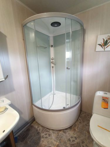 Установлена современная душевая конструкция с низким основанием, герметично закреплены стеклянные панели, подключены водопроводные коммуникации, проверена функциональность всех элементов.