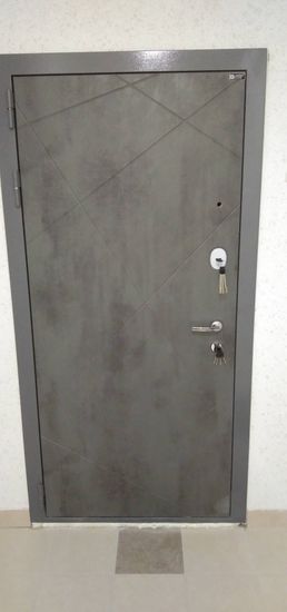 Установлена металлическая дверь с замком и ручкой, выполнена отделка проема, обеспечена надежная фиксация, проверена работоспособность механизмов, добавлены уплотнители для герметичности.