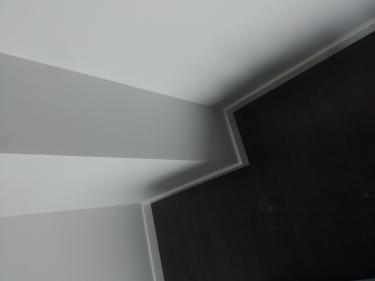 Установлены новые плинтусы вдоль стен, аккуратно подогнаны по углам. Завершено оформление стыков, обеспечена ровная линия и плотное прилегание к поверхности пола и стен.