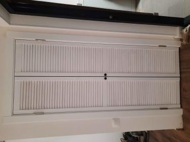 Установлены двустворчатые двери, закреплены петли, отрегулированы створки, проверена плавность открывания, добавлены ручки, завершена отделка проема, обеспечена надежная фиксация конструкции.