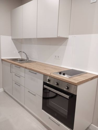 Установлены шкафы, закреплены фасады, смонтирована столешница, подключены мойка и варочная панель, встроена духовка, установлены розетки, выровнены поверхности, отрегулированы дверцы.