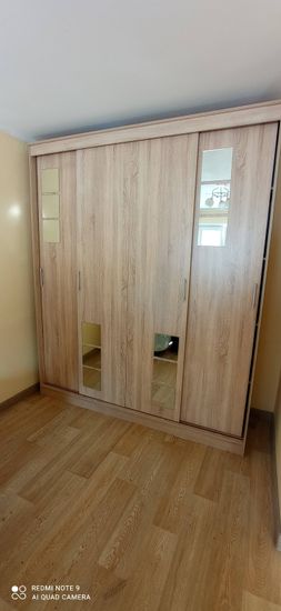 Собран вместительный шкаф с раздвижными дверцами, оснащён зеркальными вставками. Установлены ручки, отрегулированы механизмы. Готовое изделие гармонично вписывается в интерьер.