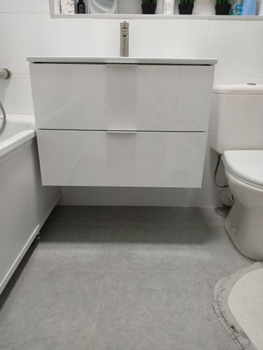 Изображение демонстрирует обновленный кухонный смеситель, установленный на белой раковине. Работа завершена, сантехника подключена, поверхность чистая, пространство аккуратное.