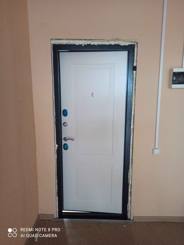 Установлена новая металлическая дверь, закреплена в проеме, обработаны стыки монтажной пеной для герметичности и утепления. Установлены ручки и замки, проверена функциональность.