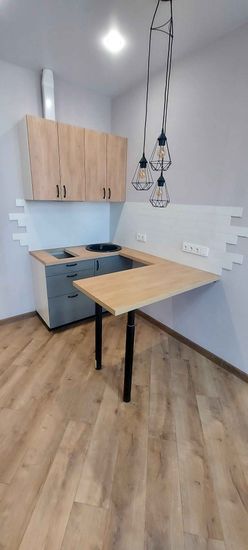 Установлены шкафы, закреплены фасады, смонтирована столешница, подключена варочная панель, раковина, установлены розетки, подвешены светильники. Завершён монтаж кухонного гарнитура.