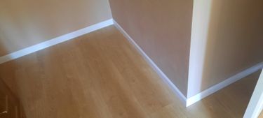 Установлен современный плинтус, скрывающий стык между стеной и полом. Аккуратная работа завершена, обеспечивая плавный переход и эстетичный вид в интерьере.