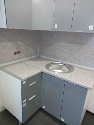 Установлена столешница с вырезом под круглую раковину, подогнана по углам, обеспечена точная подгонка к шкафам. Завершена обработка краев и монтаж на кухне.