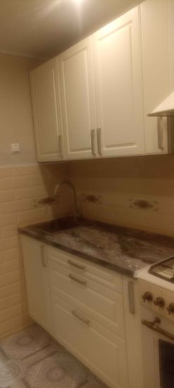 Установлены шкафы, закреплены фасады, смонтирована столешница, подключена мойка, закреплены ручки, установлена варочная поверхность, проведены коммуникации, завершена отделка стен.