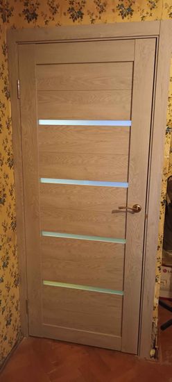 В деревянной двери выполнено отверстие, установлена защелка, закреплена ручка. Все элементы надежно зафиксированы, обеспечивая плавное закрытие и открытие.