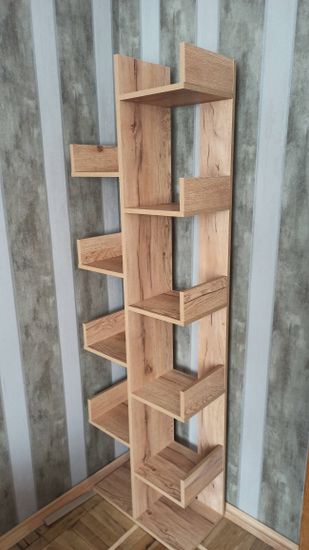 Собран деревянный стеллаж с полками, установлен у стены. Конструкция устойчивая, выполнена аккуратно, все детали плотно соединены, обеспечивая надежность и долговечность.