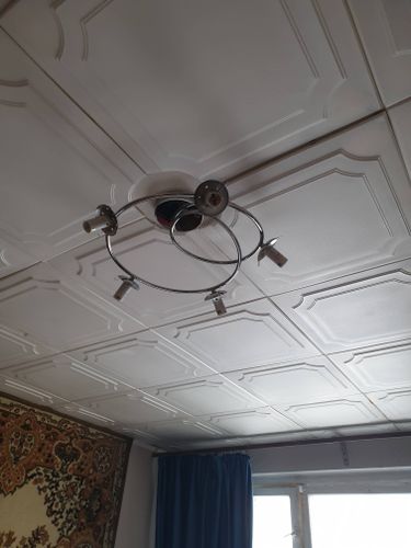 Закреплена люстра на натяжном потолке, подключены провода, установлена основа, проверена надежность крепления, обеспечена безопасность конструкции, завершены все монтажные работы.