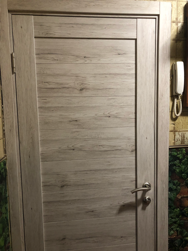 На деревянной створке установлено запорное устройство. Выполнены вырезы для механизма, ручки и защелки. Все элементы аккуратно закреплены, обеспечивая надежное функционирование.