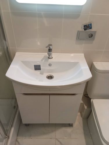 Установлена раковина с краном, подключены водопроводные трубы, герметично закреплены соединения, проверена работа системы, выполнена отделка вокруг, обеспечена функциональность и эстетичность.