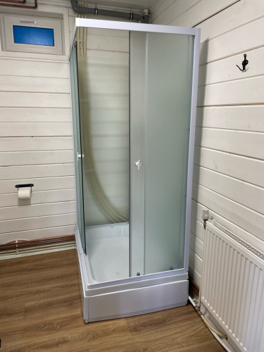 Изображение демонстрирует завершенный процесс разборки душевой конструкции: удалены панели, отсоединены трубы, демонтирован поддон, освобождено пространство для дальнейших работ.