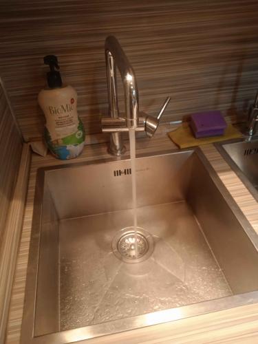 Изображение демонстрирует чистую раковину с текущей водой, рядом стоит мыло и губка. Работа завершена, засор устранен, вода свободно стекает, обеспечивая бесперебойное функционирование.