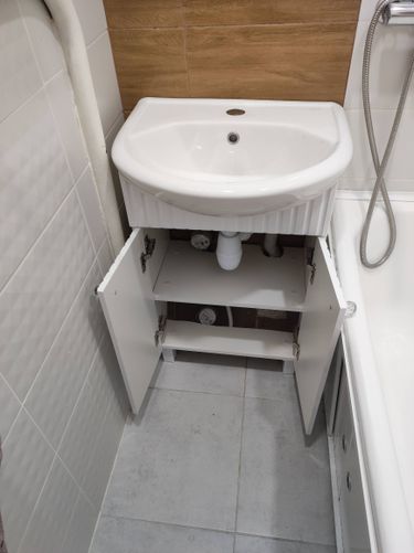 Установлены трубы для холодной и горячей воды, подключены смеситель и раковина, смонтирован сифон, проведены коммуникации под ванной, обеспечен доступ к вентилям через шкафчик.
