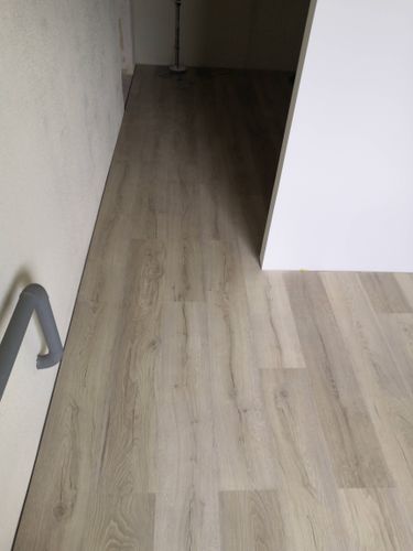 На ровное основание уложено покрытие из ламината, обеспечивая гладкую и эстетичную поверхность. Пол выглядит аккуратно, с четко подогнанными стыками и ровными линиями.