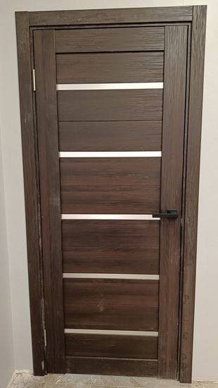 Установлено полотно из дерева, закреплены петли, смонтирована коробка, врезан замок, прикреплена ручка, отрегулированы зазоры, выполнена отделка наличниками, проверена плавность открывания.