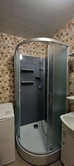 Изображение ванной комнаты с душевой кабиной, стиральной машиной и раковиной. Установка завершена, подключены коммуникации, проверена работа, обеспечена герметичность соединений.
