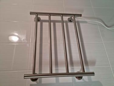 На стену закреплён металлический прибор с подключением к электросети. Устройство надёжно зафиксировано, кабель аккуратно уложен. Работа выполнена качественно, оборудование готово к использованию.