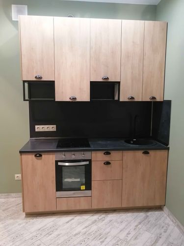 Установлены шкафы, закреплены дверцы, смонтирована столешница, подключена варочная панель, врезана мойка, подключены розетки, выполнена подгонка элементов, завершена сборка.