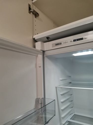 Регулировка фасада, дверцы холодильника.  Установка полкодержателя и полки.  Очистка от старого герметика столешницы и повторное нанесение его (заполнение пустот).