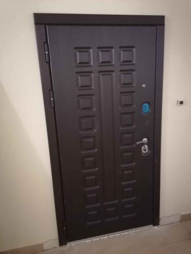 Изображена завершенная работа: установлена новая пластиковая дверь с надежными петлями и современным замком. Аккуратно выполнены отделочные работы вокруг проема.