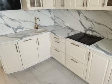 На кухне установлена новая столешница из ДСП. Выполнен монтаж раковины и варочной панели, подведены коммуникации. Все элементы надежно закреплены и выровнены по уровню.