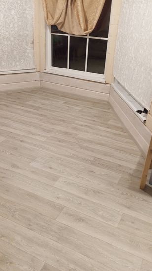 Покрытие уложено на ровное основание, стыки аккуратно соединены, края прижаты к плинтусам. Поверхность гладкая, без дефектов, узор выровнен, обеспечена прочная фиксация.