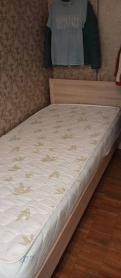 Собрана новая кровать: установлены боковины, закреплено изголовье, уложен матрас. Все элементы надежно соединены, конструкция устойчива, готова к использованию.