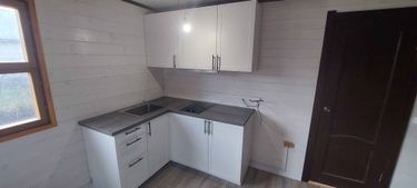 Установлены шкафы, закреплена столешница, вмонтирована мойка, подключена варочная панель. Все элементы собраны и выровнены, обеспечена функциональность и эстетика интерьера.