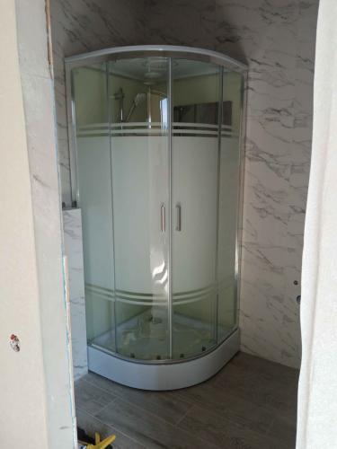 Установлена душевая конструкция с низким основанием, закреплены стеклянные панели, подключены водопроводные системы, проверена герметичность соединений, выполнена отделка стен и пола.
