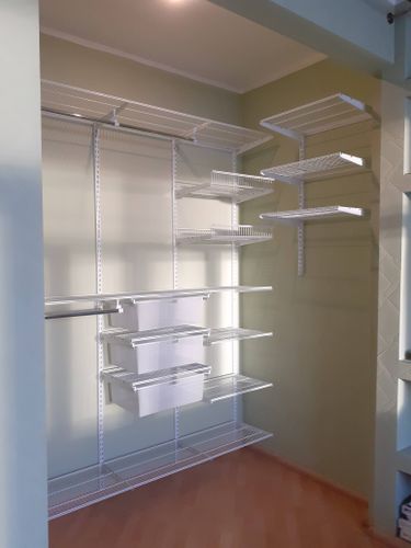 Установлены металлические полки и корзины на стене, обеспечивающие удобное хранение и организацию вещей в комнате. Стеллажи закреплены надежно, что гарантирует их долговечность.