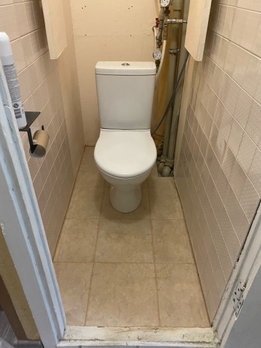 Уложена плитка на пол и стены, швы аккуратно заделаны. Установлен унитаз, трубы и коммуникации спрятаны. Ванная комната обновлена, создавая чистый и современный вид.