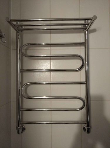 Установлен водяной полотенцесушитель на стену, подключены трубы к системе водоснабжения, проверена герметичность соединений, проведены испытания на работоспособность, завершена отделка.