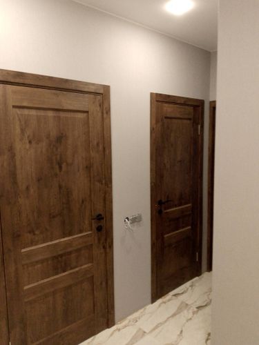 Установлена деревянная створка, закреплены петли, врезан замок, прикреплены ручки. Проведена регулировка, проверена плавность закрытия, зазоры устранены, наличники установлены.