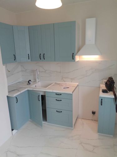 Установлены шкафы, закреплены дверцы, смонтирована столешница, подключена мойка, установлена вытяжка. Завершена сборка и монтаж кухонной мебели и техники.